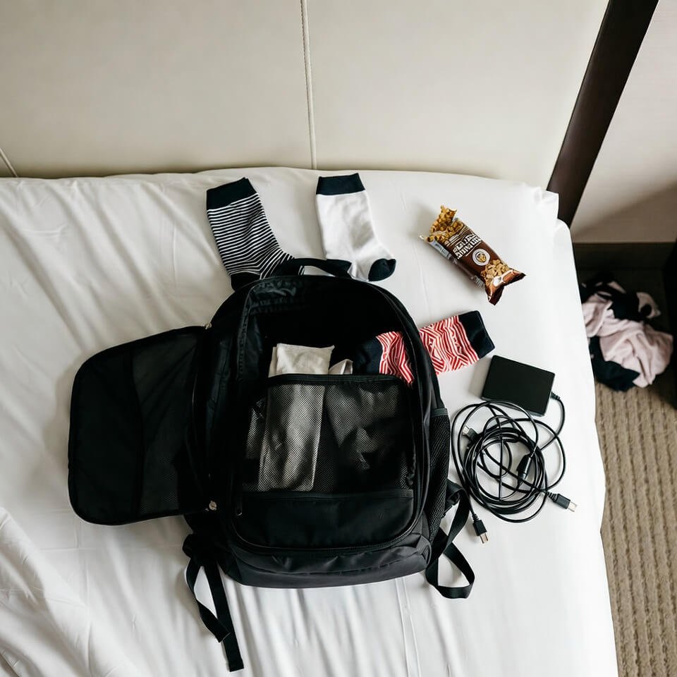 Messy hotel bed packing fail with granola wrapper