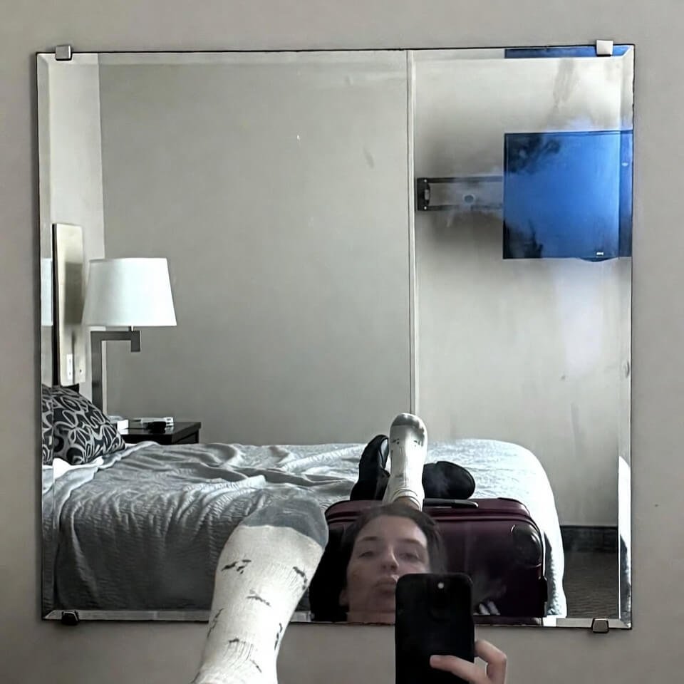 Tired mirror selfie struggling with half-on compression socks